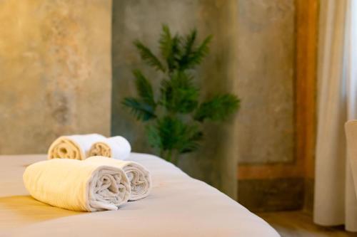 two rolled towels sitting on top of a bed at San Giacomo Suites in Città di Castello