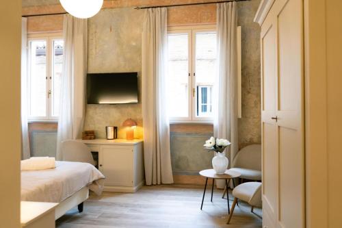 a bedroom with a bed and a desk and windows at San Giacomo Suites in Città di Castello