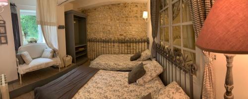 a bedroom with two beds and a chair and a lamp at Gîte "Le Bleu D'Orage" Dans un Domaine de 7ha Au Calme in Vimoutiers