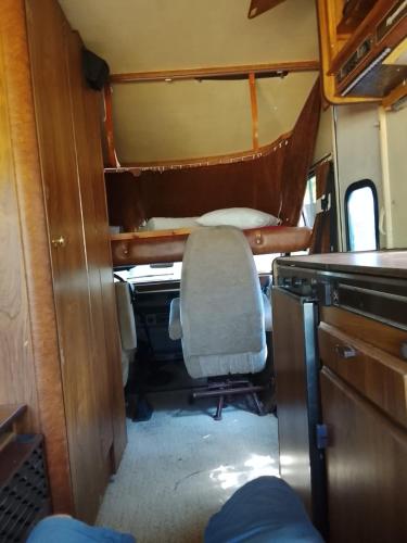 a small room with a chair in an rv at Autocaravana in Port Saplaya