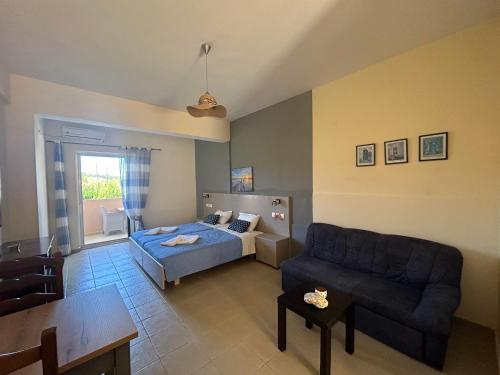 a living room with a bed and a couch at Spiros & Maria Hotel in Agios Stefanos