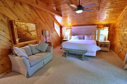a bedroom with a bed and a couch in a cabin at The Highland in Cherokee