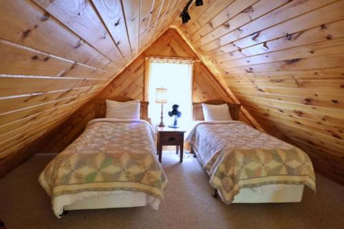 a bedroom with two beds in a log cabin at The Ridge in Cherokee
