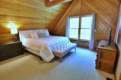 a bedroom with a bed and a window in a log cabin at The Oakes in Cherokee