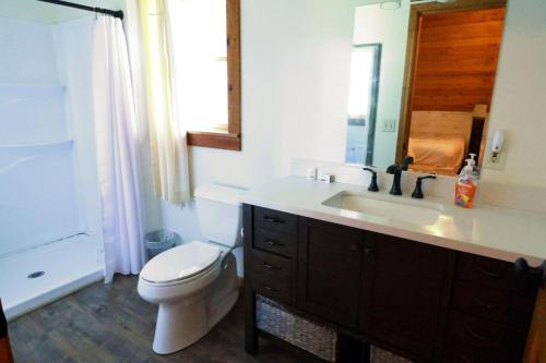 a bathroom with a toilet and a sink and a mirror at The Oakes in Cherokee