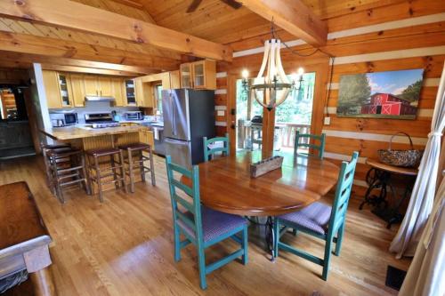 a kitchen and dining room with a wooden table and chairs at The Hilltop in Cherokee