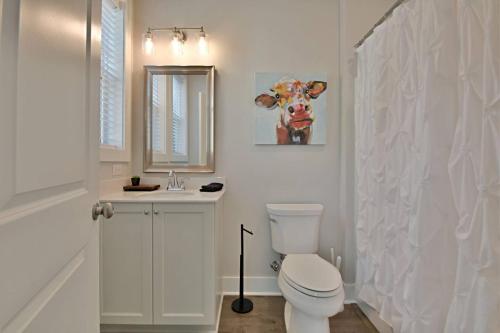 a white bathroom with a toilet and a sink at Rooftop Balcony with River View in SoKnox in Knoxville