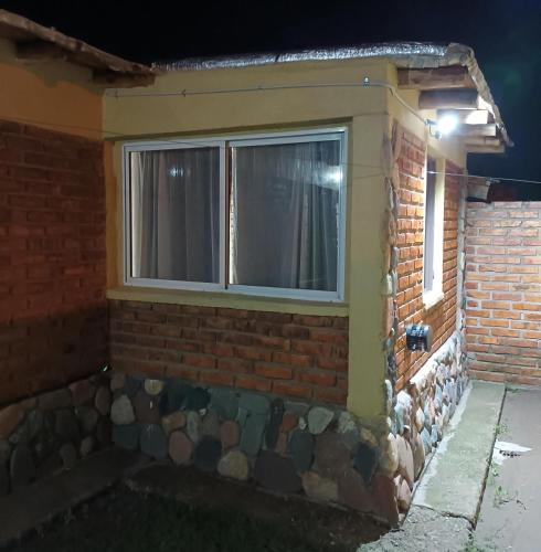a window on the side of a brick building at El Volcán in Tupungato