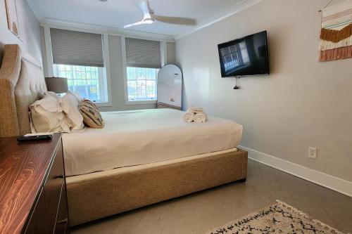a bedroom with a large bed and a flat screen tv at The Nama Retreat 201 - Renovated Downtown Loft near Gay St | Walk Everywhere in Knoxville
