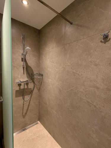 a shower in a bathroom with a stone wall at FeWo Hess in Rust