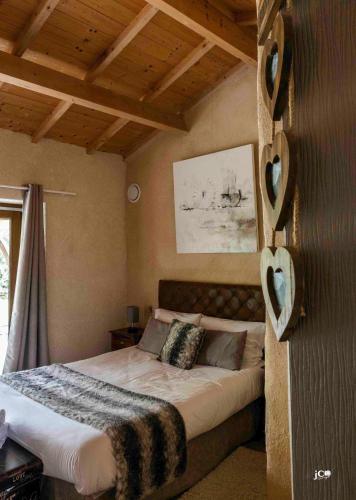 a bedroom with a bed with a wooden ceiling at Le Petit courault in Pamproux