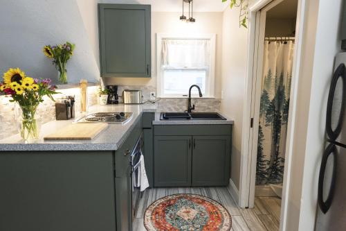 a kitchen with green cabinets and a sink at The Garden House in Saco