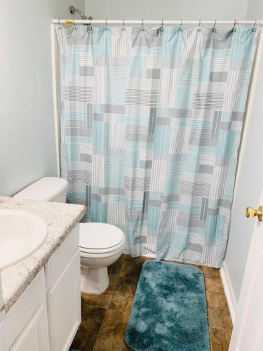 a bathroom with a toilet and a shower curtain at Covington Station Escape in Lithonia