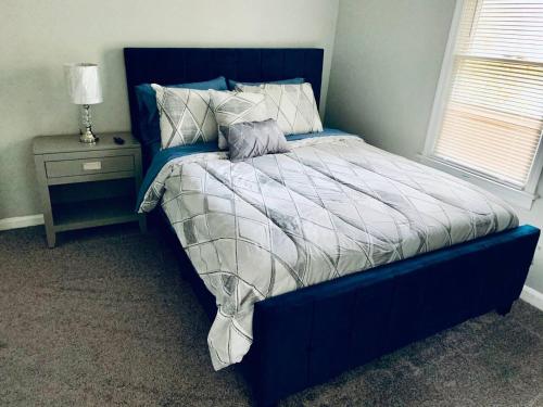 a blue bed in a bedroom with a night stand at Hartsfield Jackson Escape in College Park