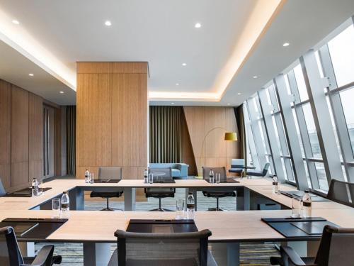 a large room with tables and chairs and windows at Sofitel Shanghai Hongqiao in Shanghai