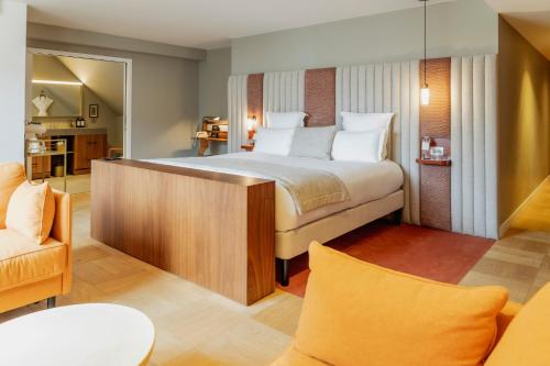 a bedroom with a large bed and a living room at Hôtel Pilgrim in Paris