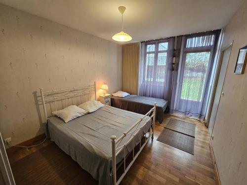 a bedroom with a bed and a window and a bed sidx sidx sidx at Le pin de la tour in Sossais