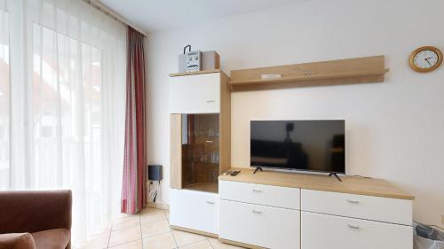 a living room with a flat screen tv on a dresser at Appartementhaus Binzer Sterne 09 in Binz