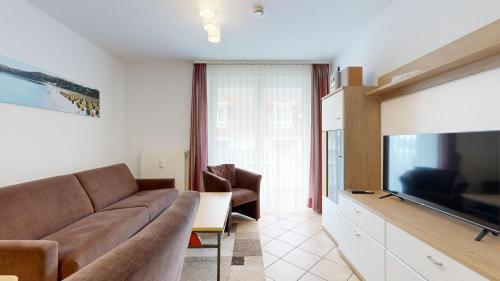 a living room with a couch and a flat screen tv at Appartementhaus Binzer Sterne 09 in Binz