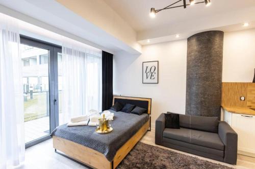 a bedroom with a bed and a couch at FRANKO APARTAMENTS - Hanza Tower in Szczecin