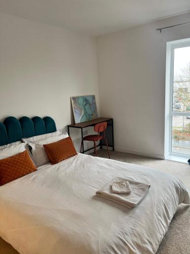 a bedroom with a large white bed with a blue head board at Prime Location - Apt - Stay 4 - Lakeside - Parking in Grays Thurrock
