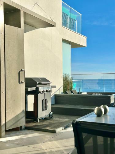 a outdoor kitchen with a grill on a patio at Feel So Good Apartment with Sea View Hot Tub in Sesimbra
