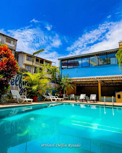 a swimming pool in front of a building at Hotel Delfin Rosado in Puyo