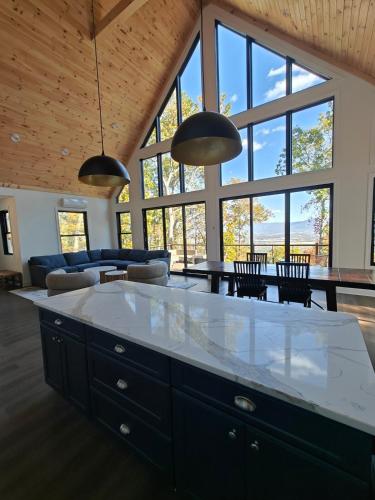 a kitchen and dining room with a large room with windows at Cliff's View Mountain Retreat in Luray