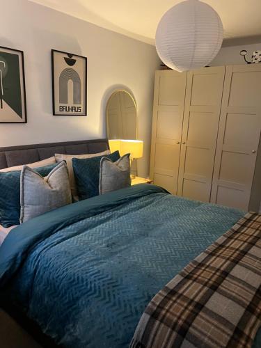 a bedroom with a bed with blue sheets and pillows at Room at Wallington Green for professionals, free parking, near station, 30 min to London Bridge, 27 min to LDN Victoria in Wallington