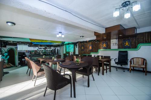 ein Restaurant mit Tischen und Stühlen in einem Zimmer in der Unterkunft Turtle Inn Resort in Boracay