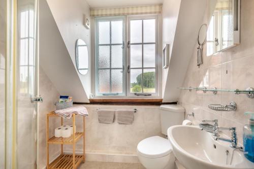 a bathroom with a sink toilet and a window at 4 Bed in East Harling oc-m31907 in East Harling
