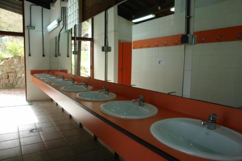 a row of sinks in a public bathroom at Camping el Cares in Santa Maria de Valdeón