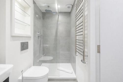 a white bathroom with a shower and a toilet at Roomspace Serviced Apartments - The Quadrant in Richmond upon Thames