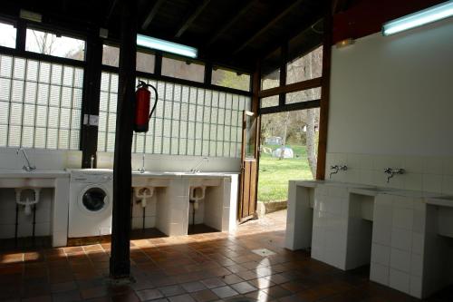 a bathroom with a washing machine in a room at Camping el Cares in Santa Maria de Valdeón