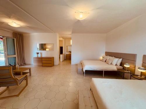 a hotel room with two beds and a couch at Villa mit großem Garten und Aufstellpool, 800m zum Meer, Lido Marini in Lido Marini