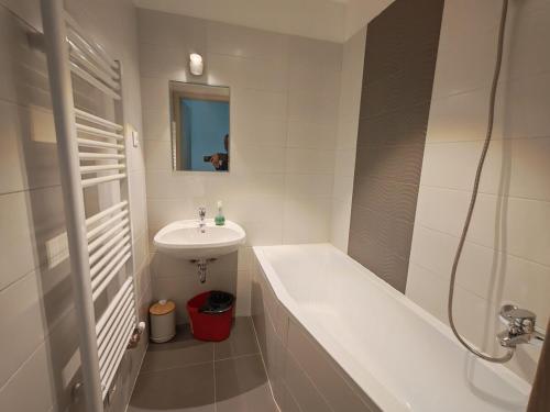 a white bathroom with a sink and a tub and a sink at Juniper 3 Business in Kecskemét