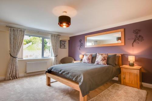 a bedroom with a bed with a mirror and a window at 2 Bed in Woolacombe oc-narr9 in Woolacombe