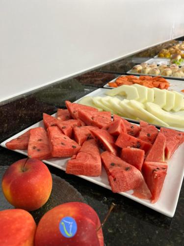a plate of watermelon and other fruit on a table at Hotel Seven in Goiânia