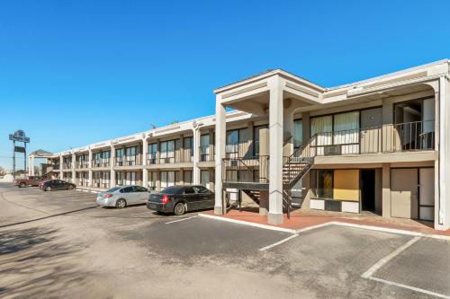 an apartment building with cars parked in a parking lot at Knights Inn San Antonio near Frost Bank Center in San Antonio