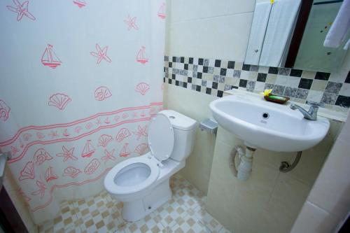 a bathroom with a toilet and a sink at Asta House in Kuta