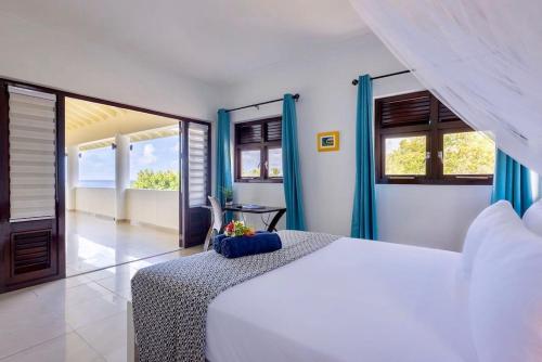 a bedroom with a white bed and some windows at Scuba Dream Villa 519 - Coral Estate in Willibrordus
