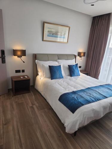 a bedroom with a large bed with blue pillows at Belvedere Boutique Living Gozo in Żebbuġ