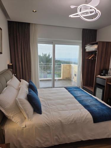 a bedroom with a large bed with a large window at Belvedere Boutique Living Gozo in Żebbuġ