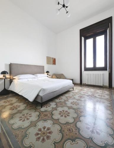 a white bedroom with a bed and a rug at TheSuperhost - Aquaria - Vista Mare in Crotone