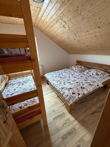 two bunk beds in a room with wooden ceilings at Wellness chata Rybárie in Klokočov