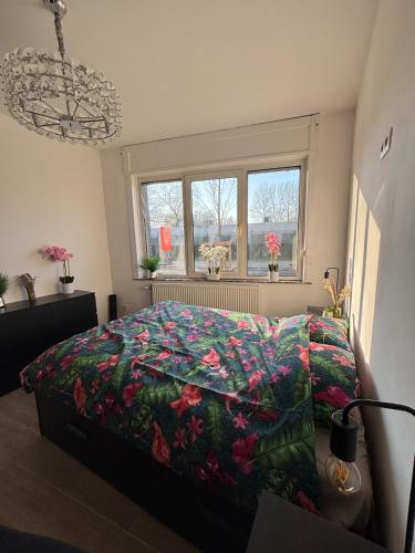 a bedroom with a bed with a floral comforter at Modern apartment in Brussels, ground floor in Brussels