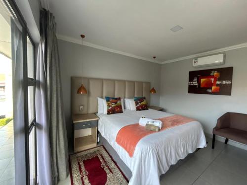 a bedroom with a large bed and a chair at Bergsig Guesthouse in Bethlehem