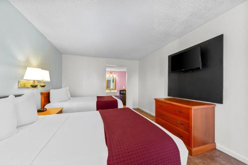 a hotel room with a bed and a flat screen tv at Knights Inn San Antonio near Frost Bank Center in San Antonio