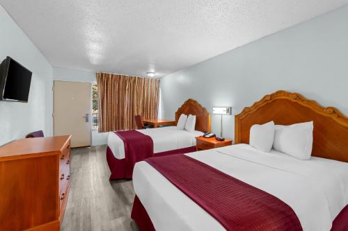 a hotel room with two beds and a television at Knights Inn San Antonio near Frost Bank Center in San Antonio
