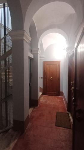 an empty hallway with a wooden door and a hallwayngth at la Ciccinina in Sarteano